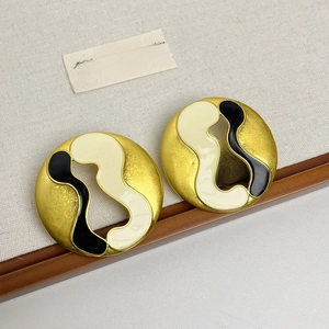 Vue détaillée de boucles d'oreilles rondes vintage en émail doré et noir chic