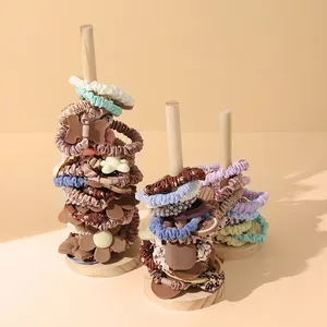 Wooden hair accessory stand displaying Morandi color scrunchies and decorative hair ties