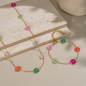 Bohemian colorful flower necklace and bracelet set on stone background for women