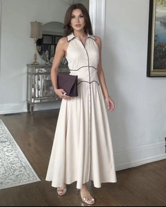 Détail d'une élégante robe longue sans manches avec col à revers et passepoil noir