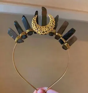Detailed macro view of handmade gold crescent moon tiara with crystal quartz stones