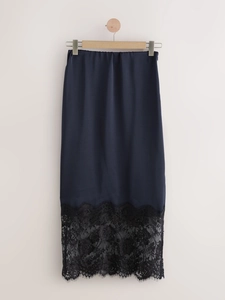 Detailed view of dark blue silk skirt featuring elegant black lace trim at the hemline