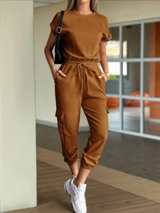 Detail view of brown short sleeve jumpsuit with drawstring waist and side cargo pockets