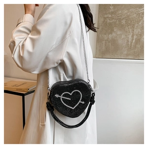Dettaglio borsa a cuore nera con strass, motivo a freccia e tracolla a catena metallica