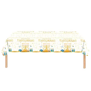 Happy Hanukkah tablecloth with gold menorah and blue gift box prints on white fabric