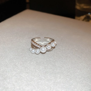 Close-up of multilayer silver ring with white pearls and sparkling zircon accents