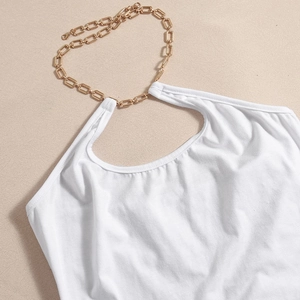 Détail de l'encolure d'une robe blanche avec chaîne dorée et texture de tissu côtelé
