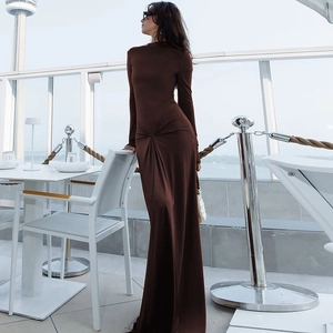 Close-up detail showing the waist twist and pleated texture of the brown maxi dress