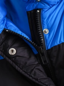 Détail macro du gilet bleu et noir avec fermeture éclair en résine et boutons pressions