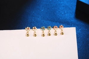Detailed view of three pairs of colorful flower titanium earrings on a white card