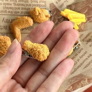 Close-up of creative realistic fried chicken leg hair clip with a metal duckbill clip