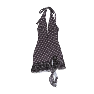 Vue à plat d'une robe dos nu rétro noire à pois blancs avec bordures à volants