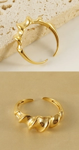 Macro detail of a twisted irregular gold plated titanium ring with a polished mirror finish