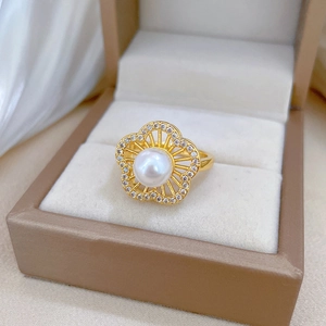 Macro shot of a gold floral ring with a large white pearl and sparkling pavé diamonds