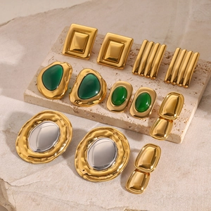 Retro gold cat eye stone and mirror stainless steel earrings set on stone display
