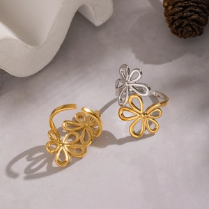 Elegant hollow floral open rings in gold and two-tone finishes on a textured base