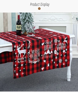 Detail van rood-zwarte kersttafelloper met ruitpatroon en feestelijke elandmotieven