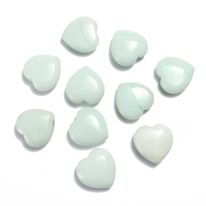 Flat lay of ten heart-shaped light green agate stones on a clean white background