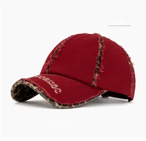 Close-up of distressed red cotton cap with leopard print patches and frayed edge detail