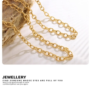 Detail of 18K gold plated thick chain necklace featuring a hammered metal texture on stone