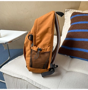 Seitenansicht des karamellbraunen Rucksacks mit Netztasche und Nylon-Stoffstruktur