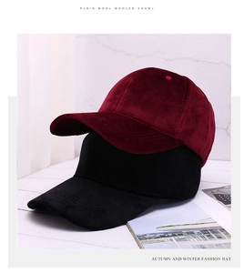 Vertical stack of burgundy and black velvet baseball caps for autumn winter fashion look