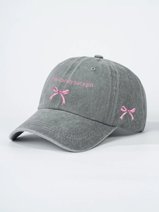 Detail view of pink 'I'm literally just a girl' embroidery on a grey washed baseball cap