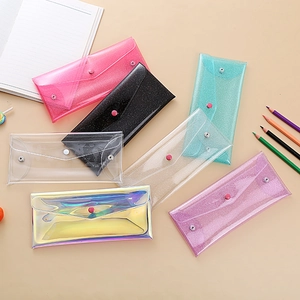 Flat lay of colorful iridescent PVC pencil bags with snap buttons and glitter finish