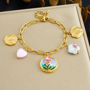 Detailed shot of a vintage gold bracelet featuring enamel flower charms and butterfly pendants