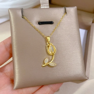 Close-up of golden tulip necklace with cat eye stone and cubic zirconia in a jewelry box