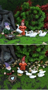 Detaillierte Nahaufnahme von Miniatur-Gartenzwergen aus Harz mit Vogelnest und weißen Enten
