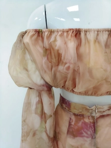 Detail of off-shoulder puff sleeves and floral print on pink chiffon two-piece set