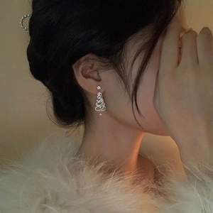 Detail of Christmas tree drop earrings with colorful zircon stones worn by a model