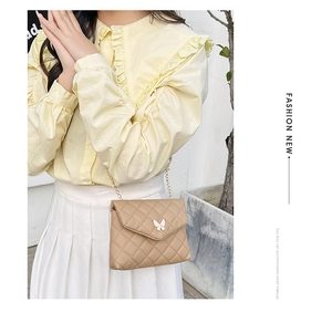Détail du petit sac carré brodé avec matelassage et fermoir papillon blanc élégant