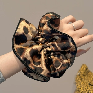 Chic double-layer leopard print silk scrunchie worn on wrist for stylish hair styling