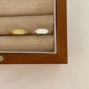 Close-up of gold and silver 925 sterling silver rings with oval animal relief engraving