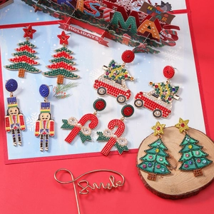Detail of Christmas beaded earrings featuring nutcracker, candy cane and festive car shapes