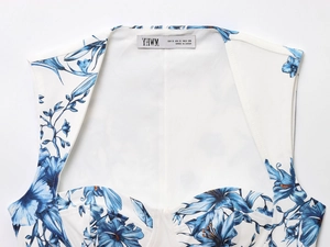Détail de l'imprimé floral bleu sur haut blanc court avec coutures structurées