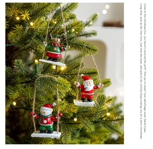 Close-up of Santa Claus, Snowman and Reindeer resin ornaments swinging on a Christmas tree