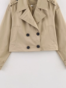Detail view of khaki double-breasted cropped trench coat jacket with twill texture fabric