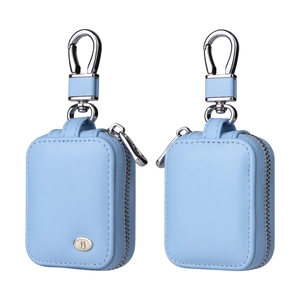 Detail of light blue grain leather earphone cases with metal zippers and carabiners