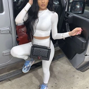 Détail de l'ensemble haut court à manches longues et legging blanc porté par un mannequin