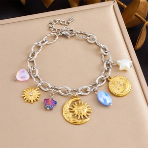 Detailed shot of celestial charm bracelet with sun, moon, and star pendants on jewelry box