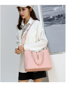Détail du sac à main rose tressé avec fermoir doré rotatif et pieds de sac protecteurs