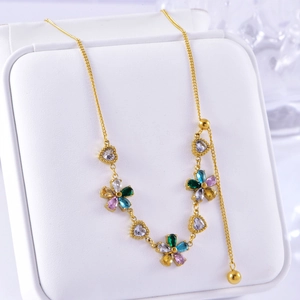 Detail of gold flower and heart necklace with colorful crystals on a white display