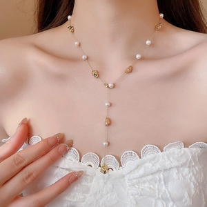 Dettaglio della collana di perle placcata oro 18k con design a goccia a Y sul collo