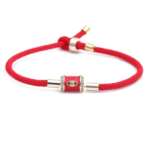 Adjustable red braided rope bracelet with golden evil eye bead and sparkling crystals