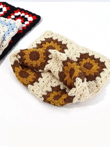 Detail of crochet beanie featuring handmade sunflower patterns and bohemian knit textures