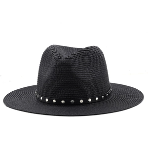 Detail of black woven fedora hat with silver studded leather band on white background