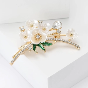 Broche fleur de prunier en émail tendance avec finition dorée et cristaux blancs élégants